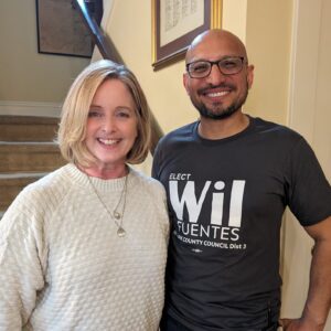 Annette Cleveland and Wil Fuentes pose for a photo at the base of a set of stairs.